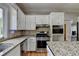 Modern kitchen boasts stainless steel appliances, granite countertops and white cabinetry at 5025 Oak Bluff Ct, Atlanta, GA 30350