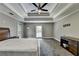 Generous primary bedroom featuring tray ceilings, a ceiling fan and natural light at 5025 Oak Bluff Ct, Atlanta, GA 30350