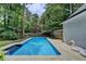 Backyard pool with mature trees surrounding the home and pool area and patio at 5025 Oak Bluff Ct, Atlanta, GA 30350