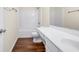 Bathroom with white cabinets, tub and shower combo and wood-look flooring at 789 Clairidge Elm Sw Trl, Lawrenceville, GA 30046