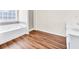 Well-lit bathroom showcasing a soaking tub and walk-in shower with wood-look floors at 789 Clairidge Elm Sw Trl, Lawrenceville, GA 30046