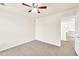 Bright bedroom with neutral walls and carpet. Features a ceiling fan and view into the home at 789 Clairidge Elm Sw Trl, Lawrenceville, GA 30046