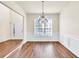Open-concept dining room with wood floors, wainscoting and chandelier at 789 Clairidge Elm Sw Trl, Lawrenceville, GA 30046