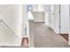 Upstairs hallway features carpet, wood railing, and multiple doors at 789 Clairidge Elm Sw Trl, Lawrenceville, GA 30046
