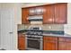 Kitchen features stainless steel gas range, wood cabinets, and granite counters at 789 Clairidge Elm Sw Trl, Lawrenceville, GA 30046