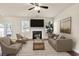 Bright living room with a fireplace, ceiling fan, and large windows for ample natural light at 789 Clairidge Elm Sw Trl, Lawrenceville, GA 30046