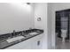 Bathroom with double vanity, black marble countertop, white cabinets, and decorative lighting at 140 Maranatha Trl, Lawrenceville, GA 30045