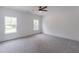 Spacious bedroom with natural light from two windows, ceiling fan, and soft carpet at 140 Maranatha Trl, Lawrenceville, GA 30045