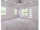 Spacious primary bedroom features plush carpeting, tray ceiling with ceiling fan, and bright natural light at 140 Maranatha Trl, Lawrenceville, GA 30045