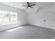 Spacious bedroom with a ceiling fan, large window providing natural light, and plush carpet at 140 Maranatha Trl, Lawrenceville, GA 30045