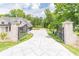 Long concrete driveway leading to an attached three car garage, secured by an ornate metal gate at 140 Maranatha Trl, Lawrenceville, GA 30045