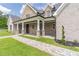 Stylish brick home showcasing a covered front porch, stone accents, and manicured landscaping at 140 Maranatha Trl, Lawrenceville, GA 30045