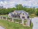 Beautiful brick home with a lush green lawn, secure black iron fence, and long concrete driveway at 140 Maranatha Trl, Lawrenceville, GA 30045