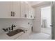 Laundry room features shaker cabinets, quartz countertops, and stainless steel sink at 140 Maranatha Trl, Lawrenceville, GA 30045