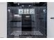 Modern bathroom showcasing a frameless shower with a rainfall showerhead, marble walls and a mosaic floor at 140 Maranatha Trl, Lawrenceville, GA 30045