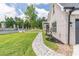 Landscaped side yard featuring a stone pathway, manicured lawn, and brick accents at 140 Maranatha Trl, Lawrenceville, GA 30045