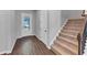 Entryway boasts wood floors, a staircase with carpet steps, and natural light from a glass door at 212 Birchwood Row, Canton, GA 30115