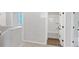 Bright hallway featuring neutral paint, white trim and doors leading to a bathroom at 212 Birchwood Row, Canton, GA 30115