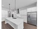 Bright kitchen features a large island, stainless steel appliances, and sleek white cabinetry at 212 Birchwood Row, Canton, GA 30115