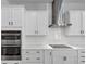Gourmet kitchen with stainless steel appliances, quartz countertops, and modern white cabinetry at 212 Birchwood Row, Canton, GA 30115
