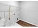 Bright laundry room with vinyl flooring, a utility sink, and white wire shelving at 212 Birchwood Row, Canton, GA 30115