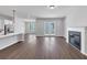 Open-concept living room features hardwood floors, a fireplace, and a modern kitchen bar at 212 Birchwood Row, Canton, GA 30115