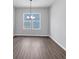 Living room with hardwood floors, ample natural light, and a modern light fixture at 212 Birchwood Row, Canton, GA 30115