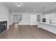 The open living area features hardwood floors, a fireplace, and a view of the modern kitchen at 212 Birchwood Row, Canton, GA 30115
