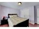 Bedroom featuring wood floors, a queen bed, and a closet with double doors at 25 Kaktovic Ct, Grayson, GA 30017