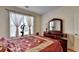 Comfortable bedroom featuring hardwood floors, large window and a dresser with mirror at 25 Kaktovic Ct, Grayson, GA 30017
