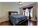 Bedroom featuring hardwood floors, dark wood furnishings, and window with decorative drapes at 25 Kaktovic Ct, Grayson, GA 30017