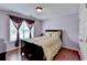 Cozy bedroom featuring a queen-sized bed, wood floors, and a window with decorative curtains at 25 Kaktovic Ct, Grayson, GA 30017