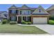 Charming two-story home featuring a brick facade, attached garage, and well-manicured lawn at 25 Kaktovic Ct, Grayson, GA 30017