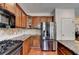 Well-lit kitchen featuring wooden cabinets, granite countertops, and stainless steel appliances at 25 Kaktovic Ct, Grayson, GA 30017