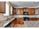 Gourmet kitchen boasts granite counters, tile backsplash, and wood cabinetry at 25 Kaktovic Ct, Grayson, GA 30017