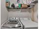 Laundry area featuring a washer, dryer, storage shelf, and a well-organized space for laundry tasks at 25 Kaktovic Ct, Grayson, GA 30017