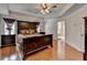 This main bedroom has hardwood floors, a large dark wood bed set, and an attached bathroom at 25 Kaktovic Ct, Grayson, GA 30017