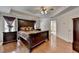 This main bedroom has hardwood floors, a large dark wood bed set, and a ceiling fan at 25 Kaktovic Ct, Grayson, GA 30017