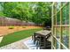 Inviting backyard featuring a patio with dining set and a lush, green lawn surrounded by a wooden fence at 2865 Ivey Oaks Ln, Roswell, GA 30076