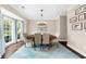 Bright dining room with large window, modern chandelier, hardwood floors, and neutral paint at 2865 Ivey Oaks Ln, Roswell, GA 30076