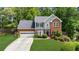 Traditional two-story home with a well-maintained lawn, lush landscaping, and an attached two-car garage at 2865 Ivey Oaks Ln, Roswell, GA 30076