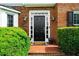 Inviting front door with sidelights and transom windows, surrounded by brick and manicured landscaping at 2865 Ivey Oaks Ln, Roswell, GA 30076