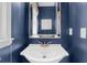 Stylish powder room with a modern vanity, gold faucet, an elegant mirror and custom blue paint at 2865 Ivey Oaks Ln, Roswell, GA 30076