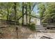 Wooded backyard with steps leading to a deck and a partial view of the pool at 600 Ponderosa Ct, Fayetteville, GA 30214