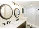 Bright renovated bathroom featuring double vanity with sleek black fixtures and subway tile shower at 600 Ponderosa Ct, Fayetteville, GA 30214
