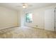 Bright carpeted bedroom with a ceiling fan and a large window view to the green outdoors at 600 Ponderosa Ct, Fayetteville, GA 30214
