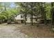 Side view of a two-story home surrounded by dense trees with brick accents and muted green siding at 600 Ponderosa Ct, Fayetteville, GA 30214