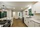 Modern kitchen featuring stainless steel appliances, white cabinets, and an island with marble countertops at 600 Ponderosa Ct, Fayetteville, GA 30214