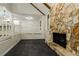 Open living area with stone fireplace, white trim, and view into a bright kitchen with white cabinets at 600 Ponderosa Ct, Fayetteville, GA 30214