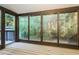 Enclosed sunroom featuring many windows with wood trim and providing views of the lush greenery outdoors at 600 Ponderosa Ct, Fayetteville, GA 30214